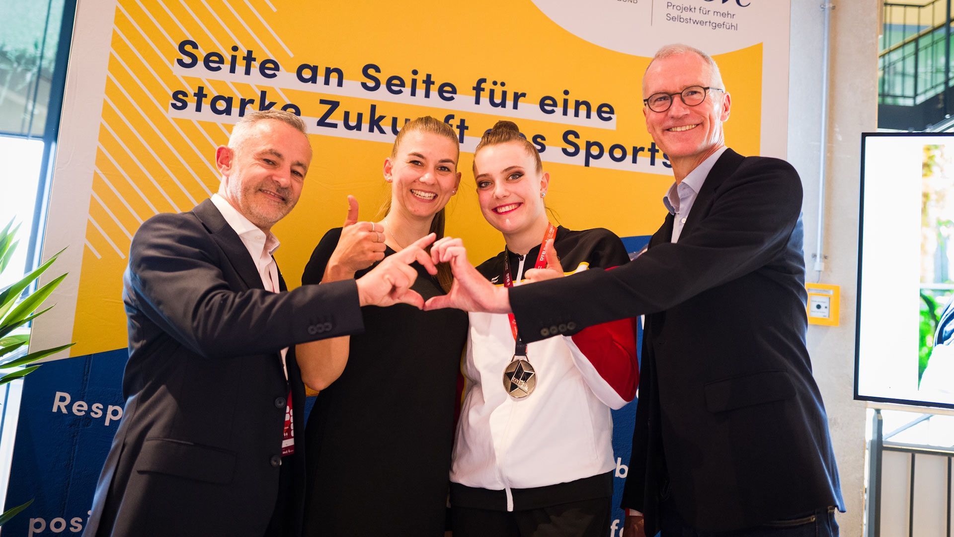 Unilever Deutschlandchef Stefan Pfeifer und weitere Personen vor einem Plakat zum Thema Zukunft des Sports.