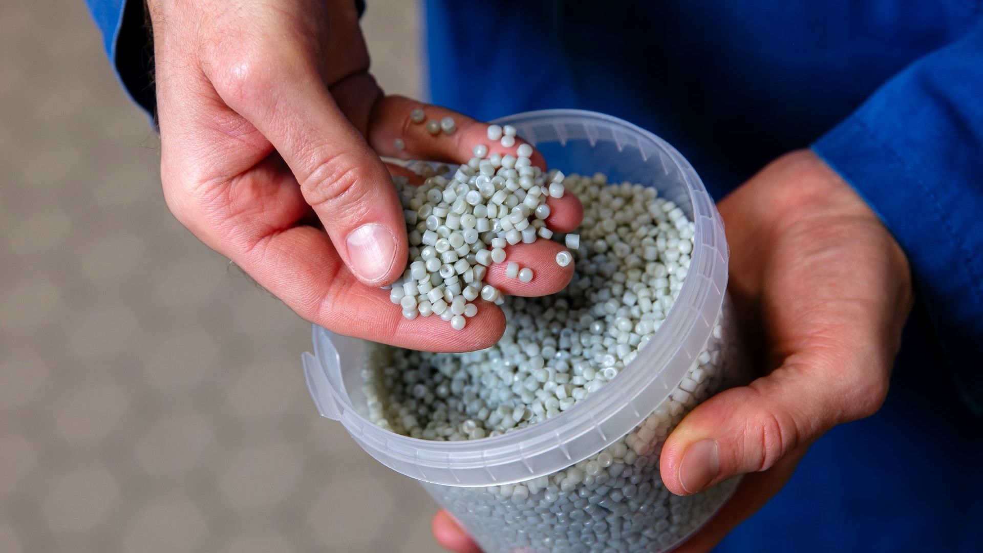 Wissenschaftler von Unilever mit einer Handvoll recycelter Kunstoffpellets