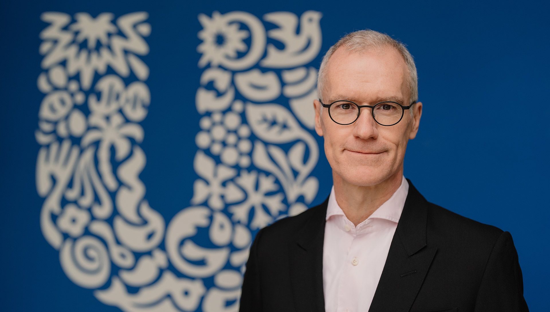 Stefan Pfeifer, Deutschlandchef von Unilever, links hinter ihm das Unilever-Logo.