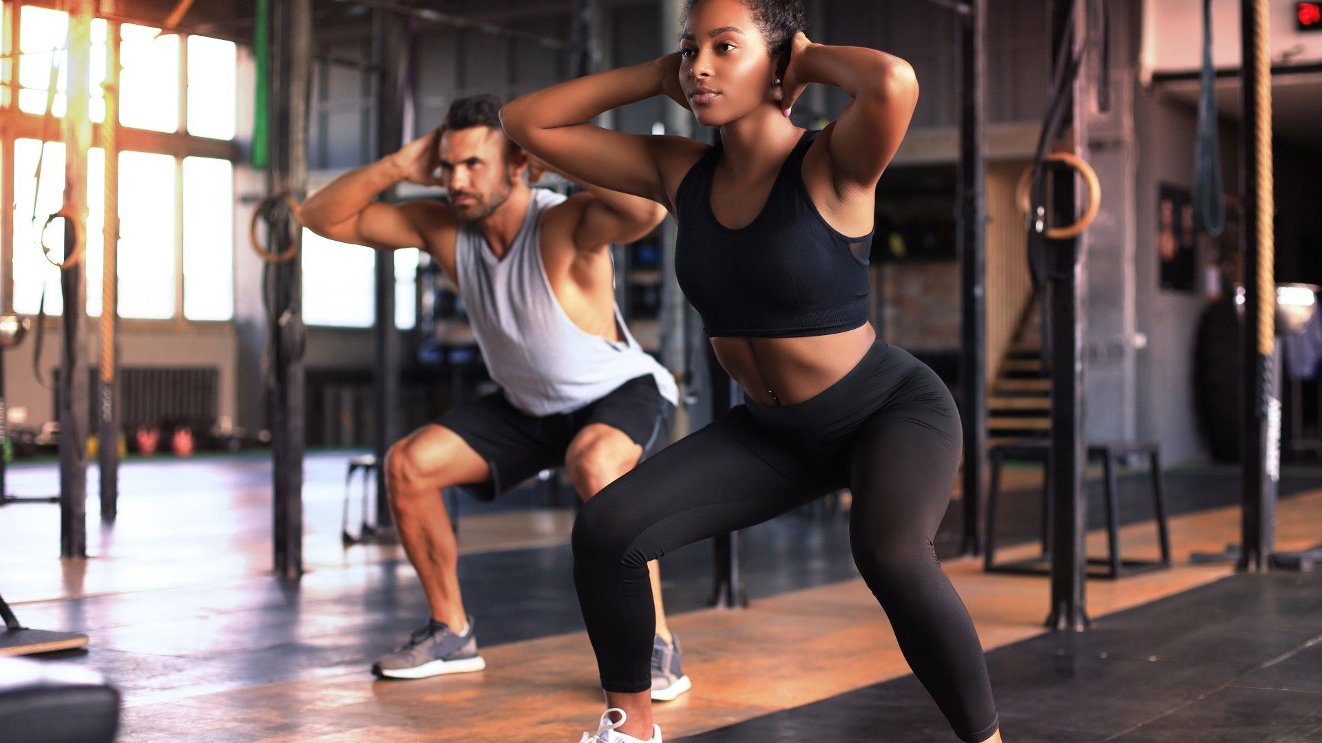 Ein Mann und eine Frau trainieren in einem Fitnessstudio.