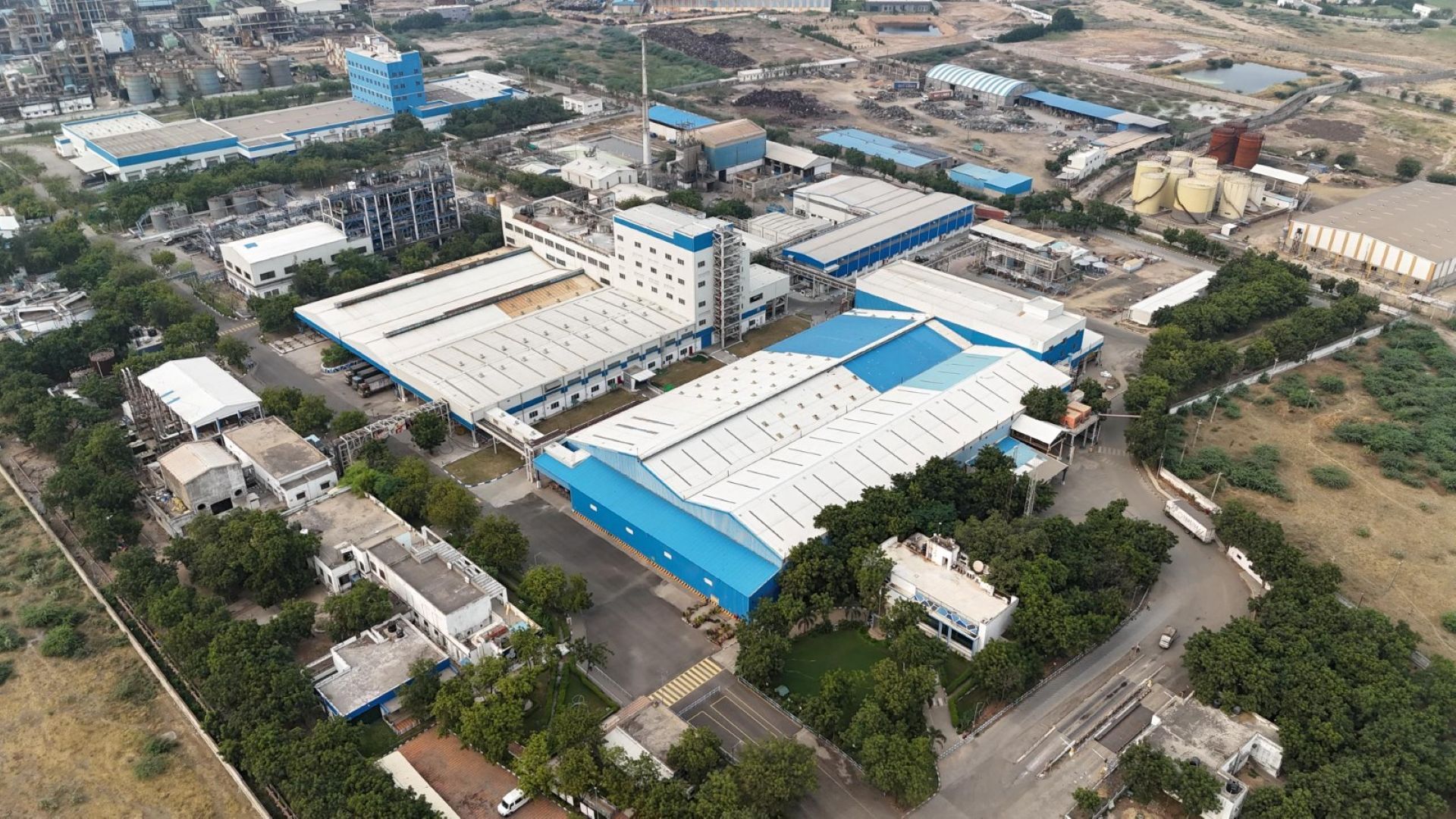 Luftaufnahme der in Weiß und Blau gehaltenen weitläufigen Unilever-Fabrik in Gandhidham, Indien.